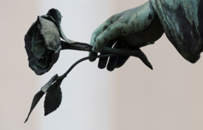 Zoomed in statue hand holding rose.